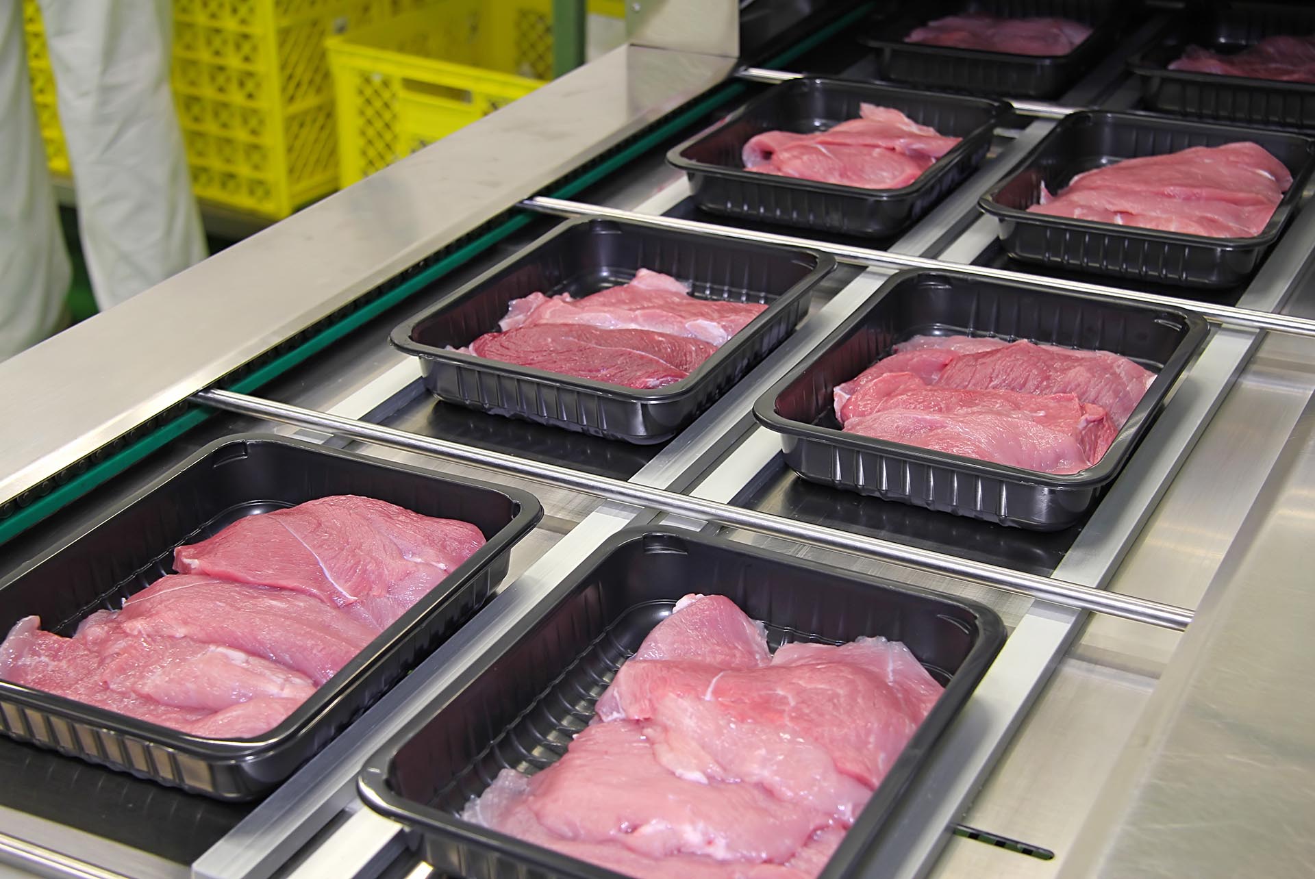 meat is being packaged in hard peelable lidding film trays